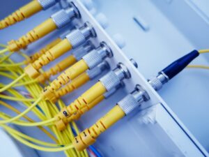 Żółte kable światłowodowe podłączone do panelu krosowego